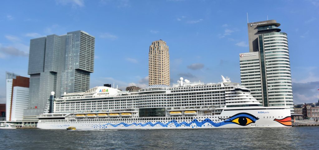 "AIDAperla" hat für 24 h angelegt. Würde es senkrecht stehen, wäre es etwa doppelt so hoch wie das dahinterstehende Hochhaus (300 m)